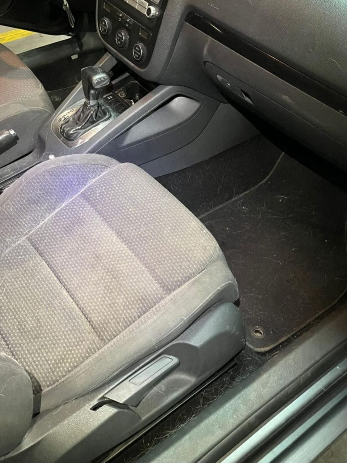 Przód wnętrza przed detailingiem — zabrudzony fotel, wykładzina i próg